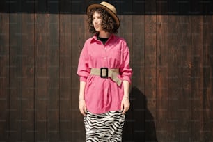 Una mujer con camisa rosa y falda con estampado de cebra
