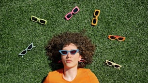 una donna sdraiata sull'erba che indossa occhiali da sole