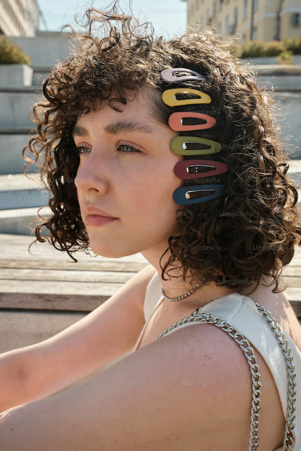 Eine Frau mit lockigem Haar hat einen Haufen Haarspangen auf dem Kopf
