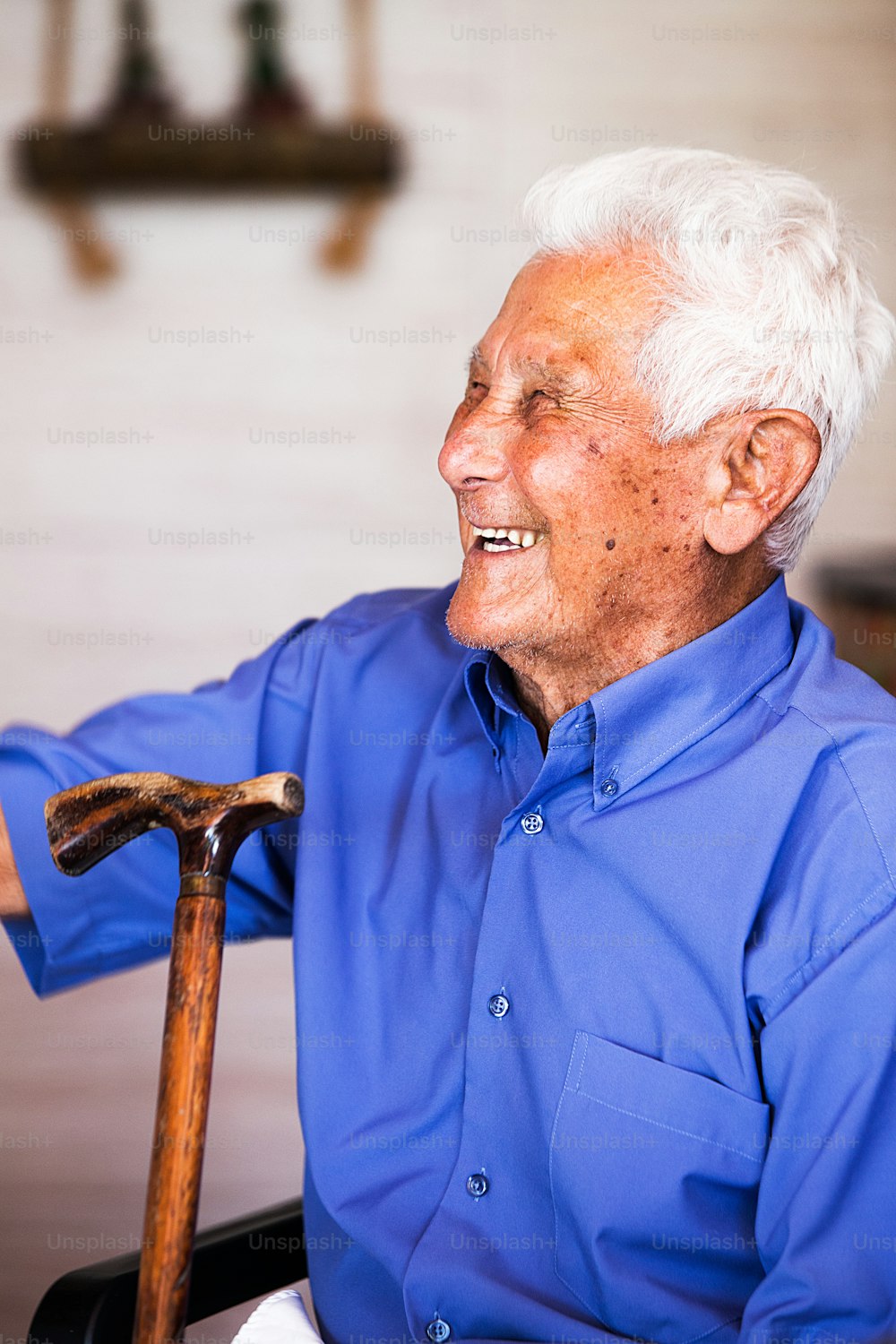 an older man sitting in a chair with a cane