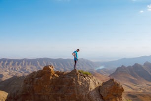 a man standing on top of a large rock