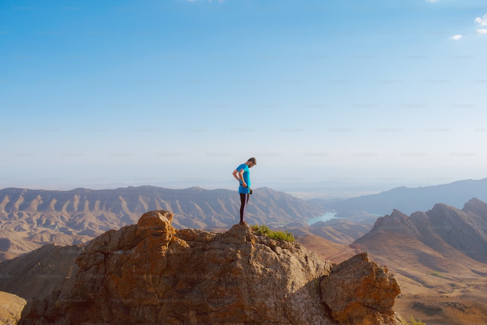 a man standing on top of a large rock