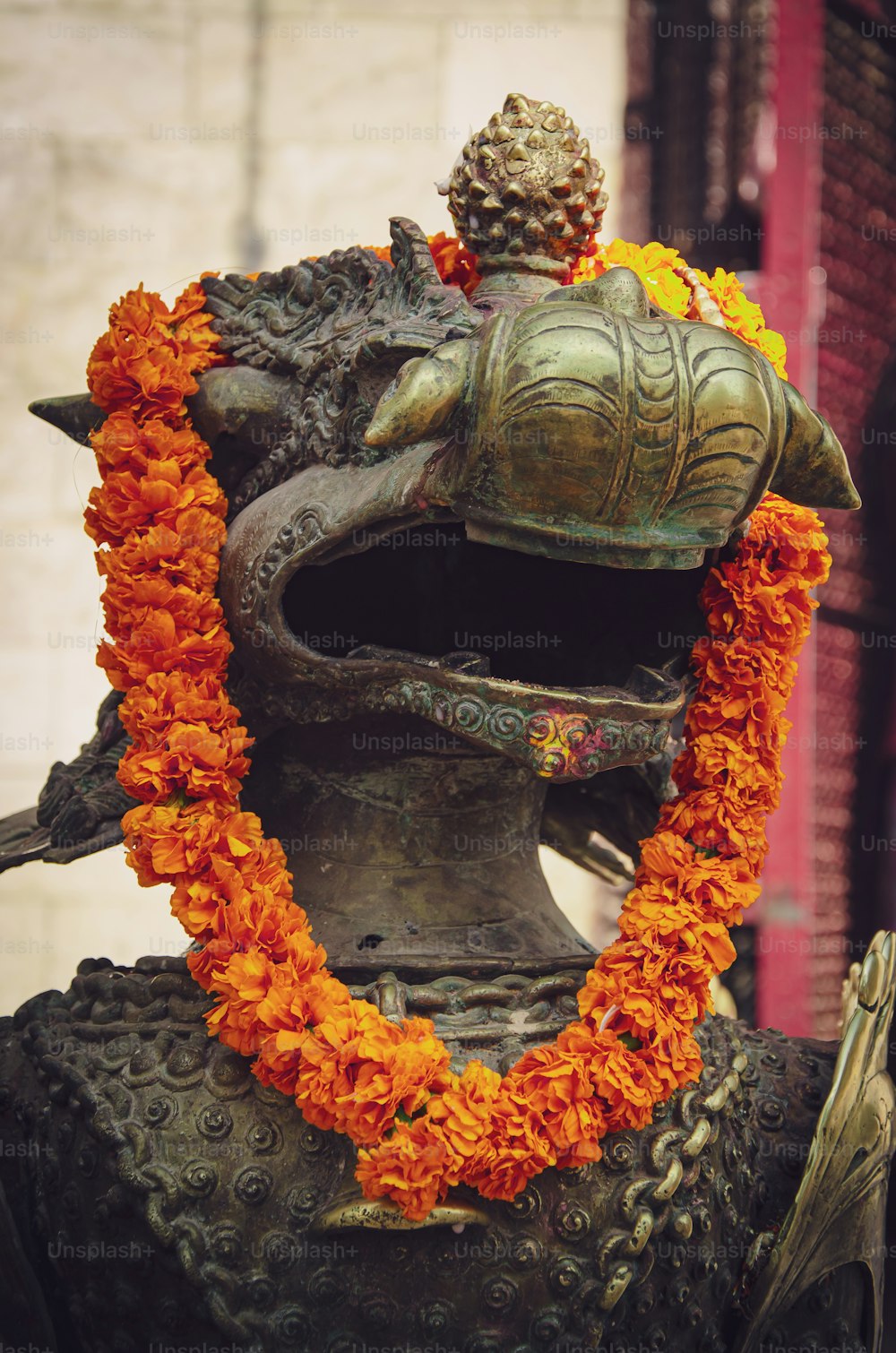 uma estátua de um homem com uma coroa de flores no pescoço