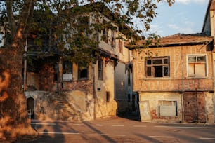 an old run down building with a tree in front of it