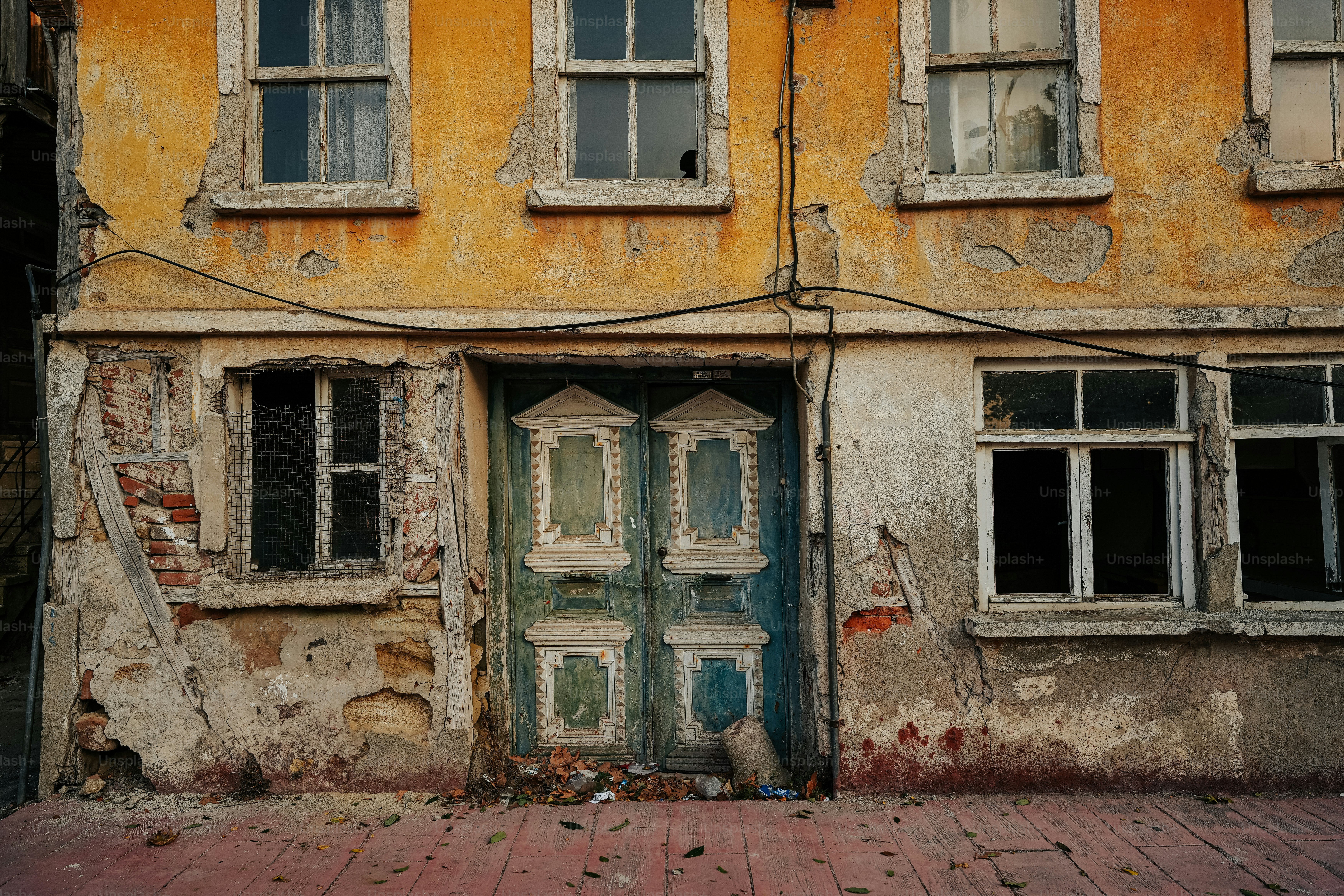 an old building with peeling paint and broken windows