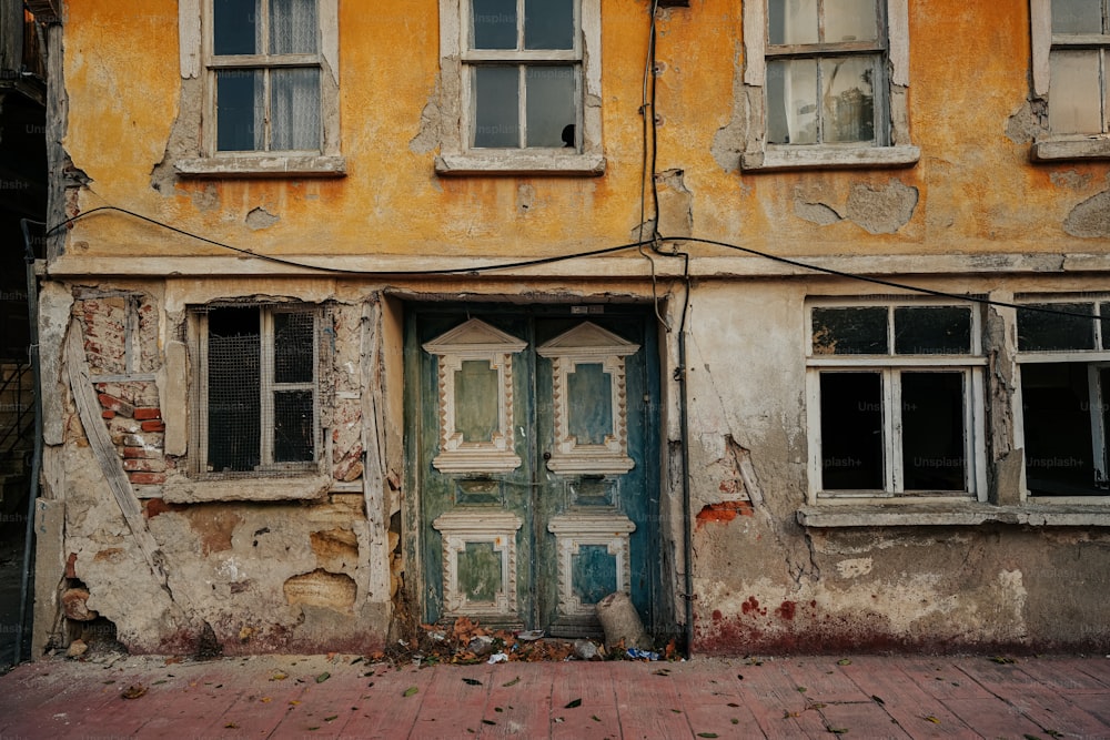 an old building with peeling paint and broken windows