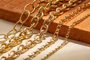 a group of gold chains sitting on top of a wooden board