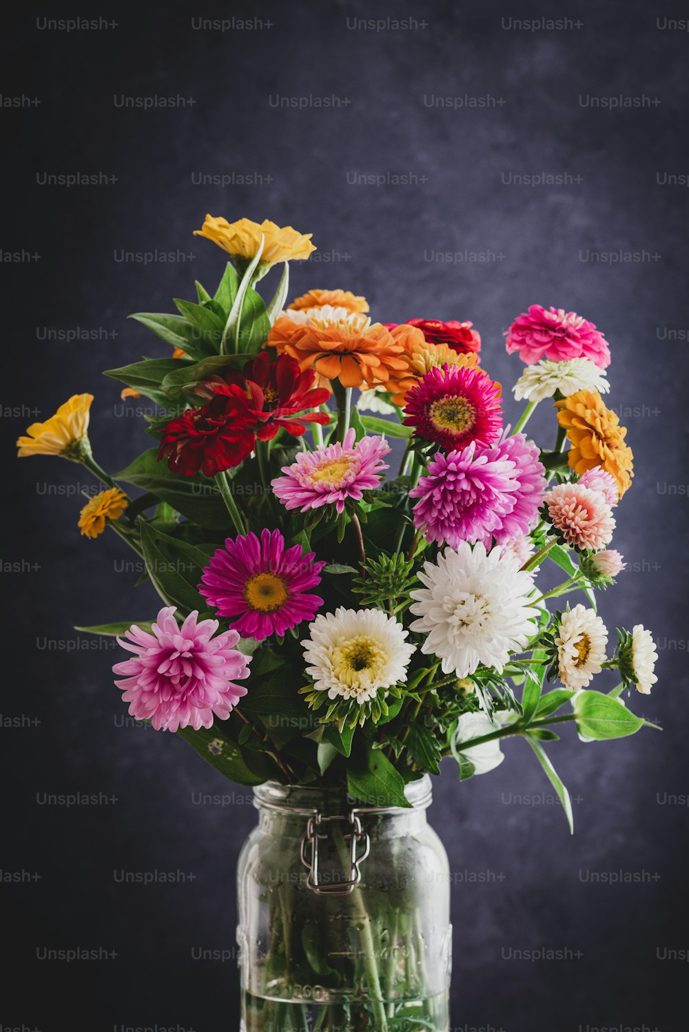 eine Vase gefüllt mit vielen bunten Blumen