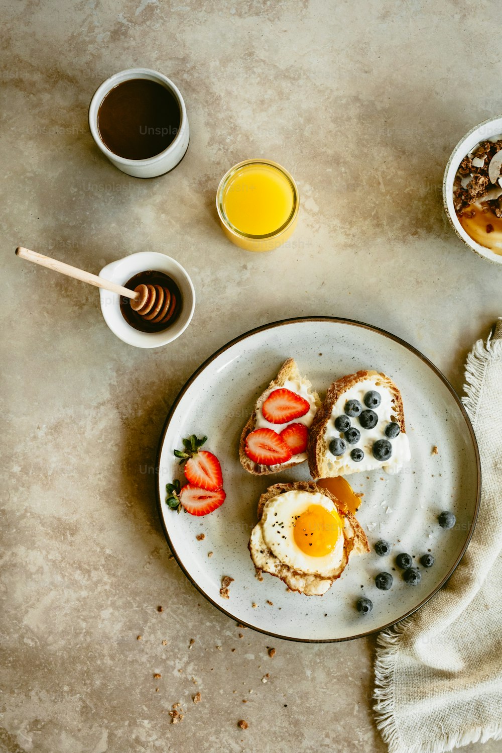 a plate of food with eggs, strawberries, and a cup of coffee