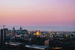 a view of a city at dusk with a train on the tracks