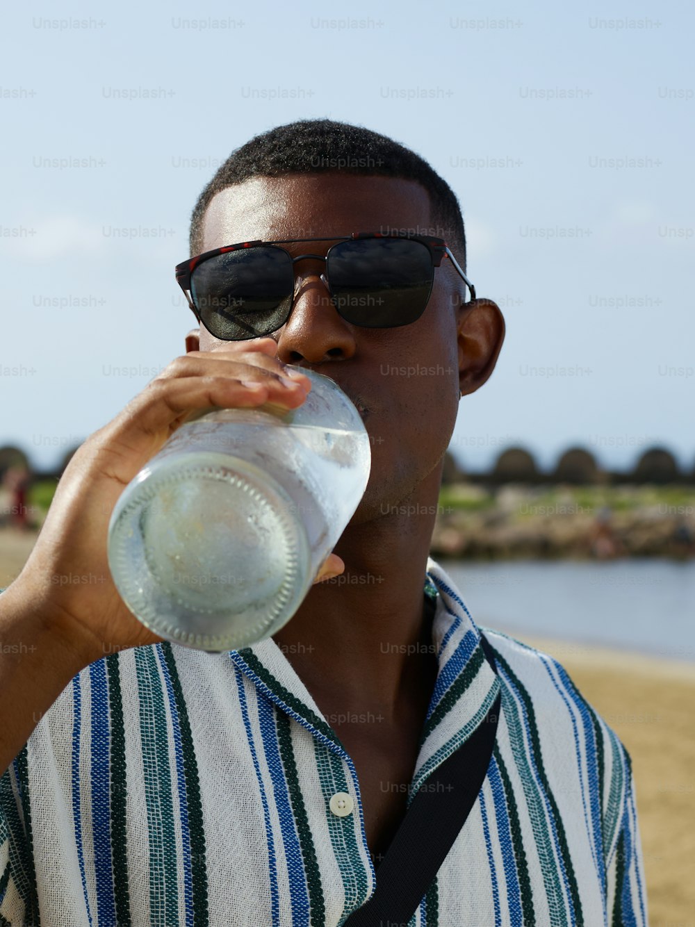 a man drinking water from a plastic bottle