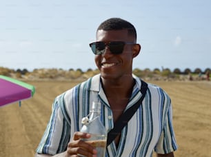 a man in sunglasses holding a bottle of water