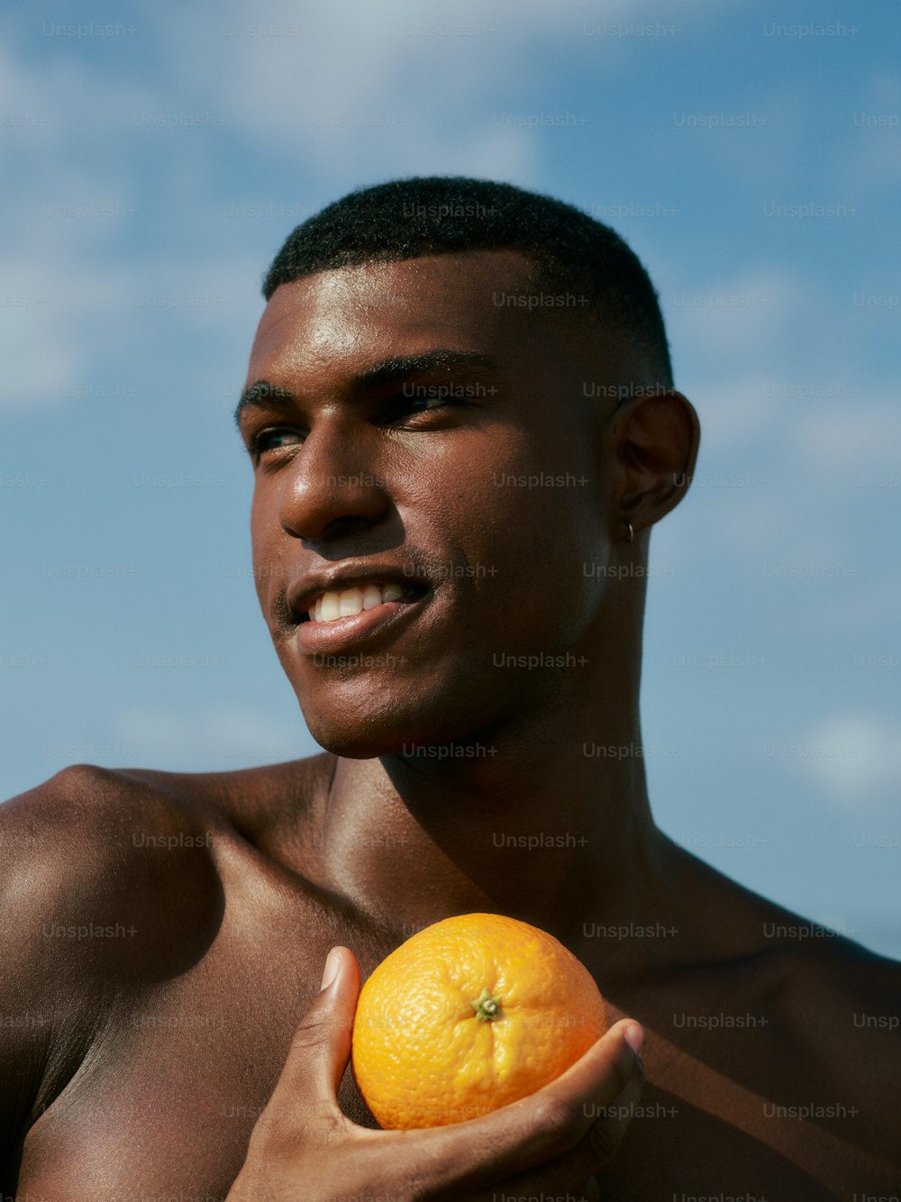 a man holding an orange in his right hand