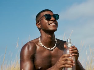 a man wearing sunglasses holding a bottle of water