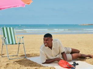 a man laying on a towel on the beach