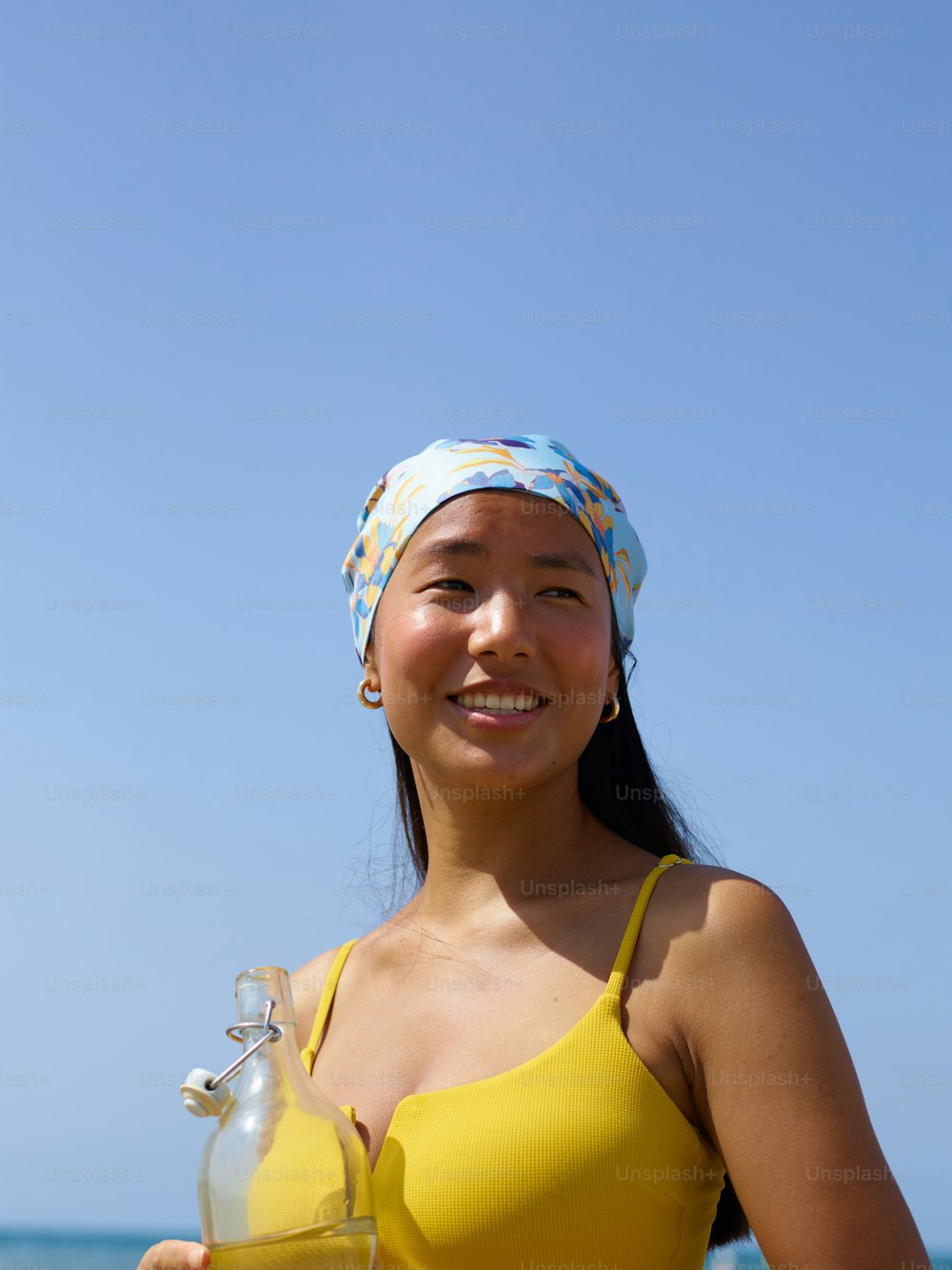 a woman in a yellow bikini holding a glass of wine