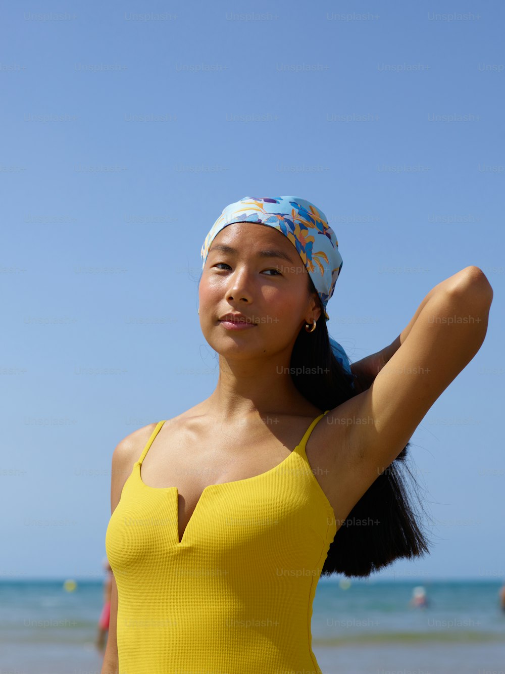 a woman in a yellow one piece swimsuit on the beach