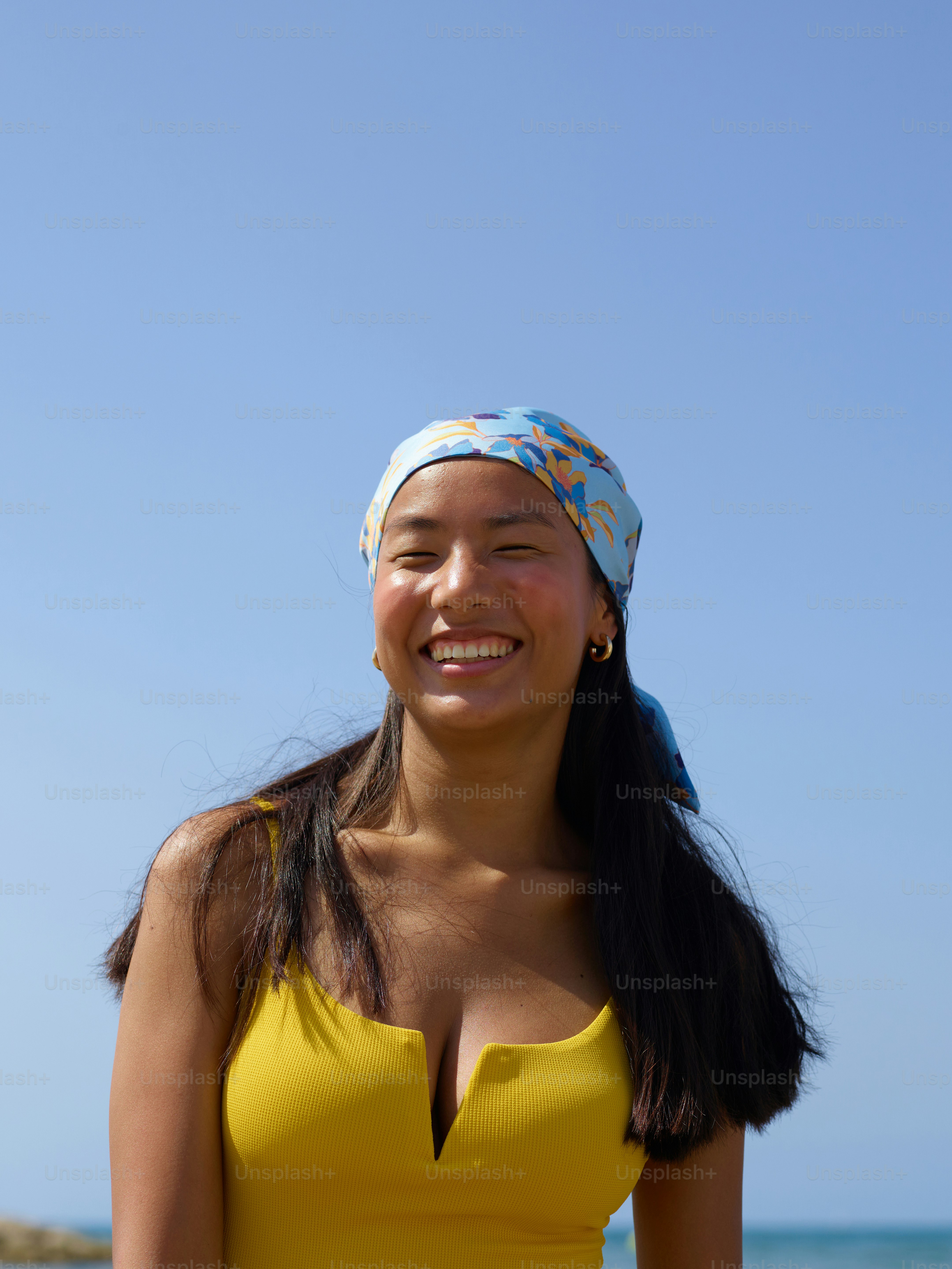 a woman in a yellow bathing suit standing on the beach