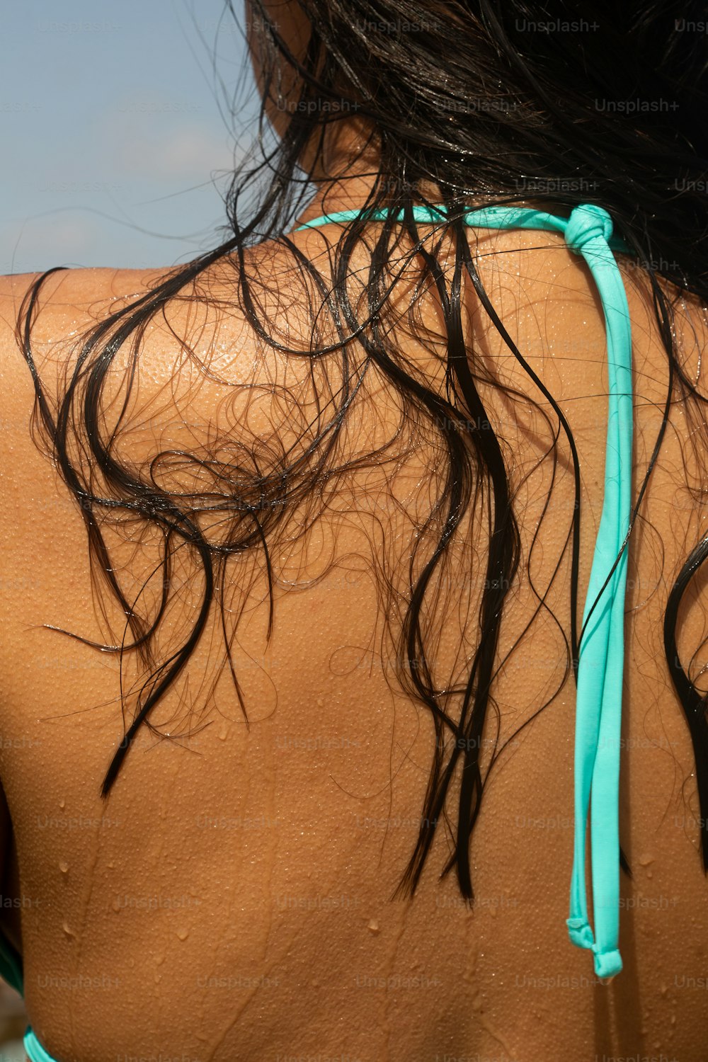 as costas de uma mulher com cabelo molhado