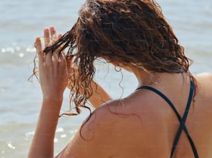 Una mujer con el pelo mojado sentada en el agua