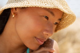 a woman in a straw hat talking on a cell phone