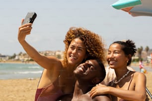 un gruppo di amici che scattano un selfie sulla spiaggia