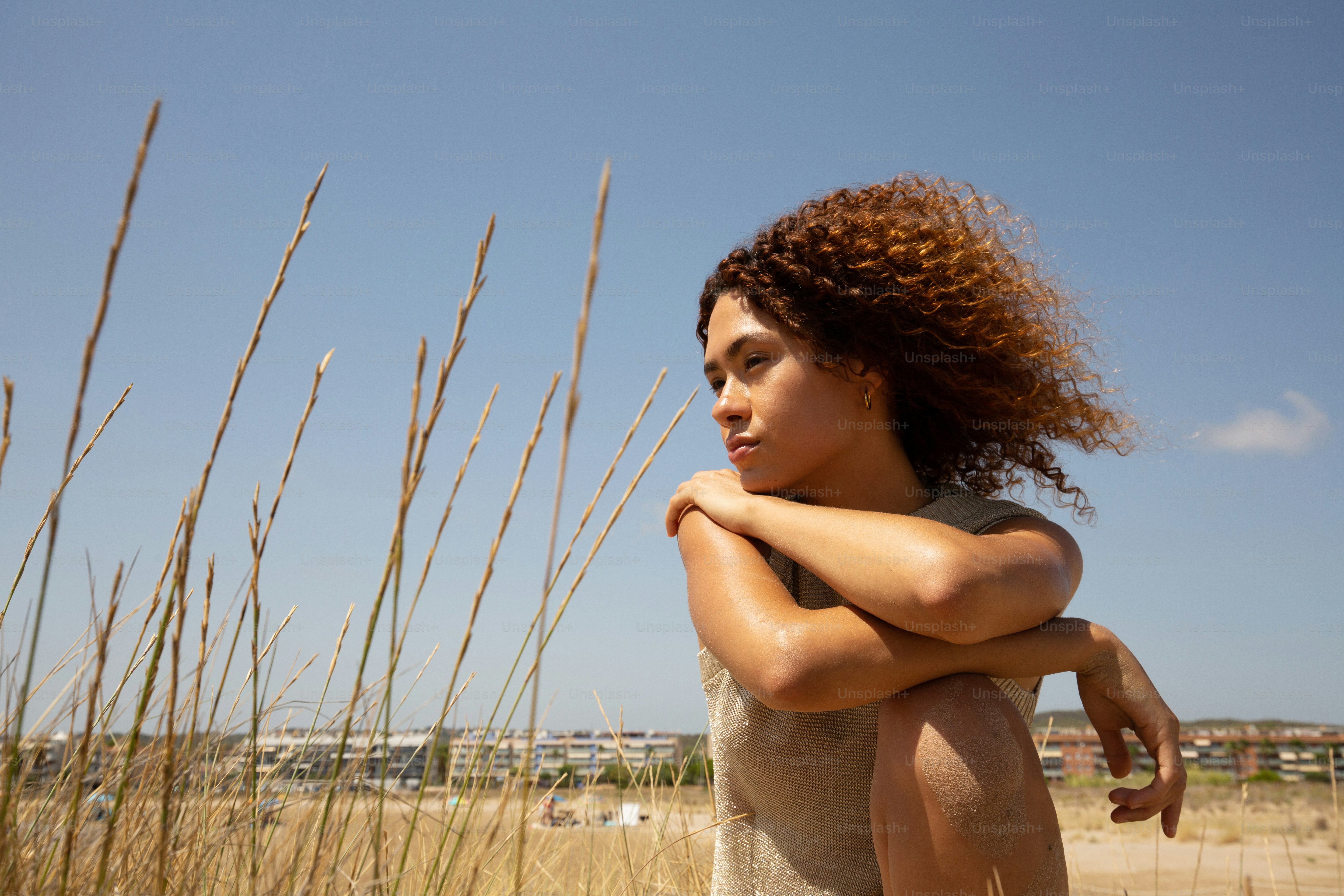 a woman standing in a field with her arms crossed