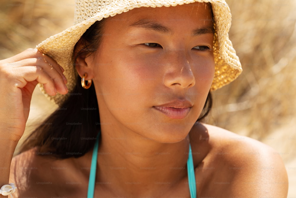 a woman wearing a straw hat and a blue necklace