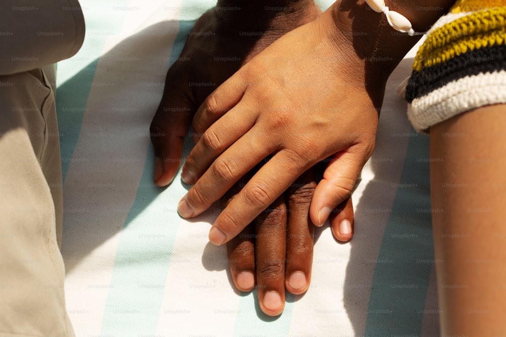 a close up of two people holding hands