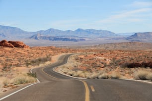 Eine Straße mitten in der Wüste mit Bergen im Hintergrund