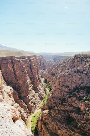 a man standing on top of a cliff next to a valley