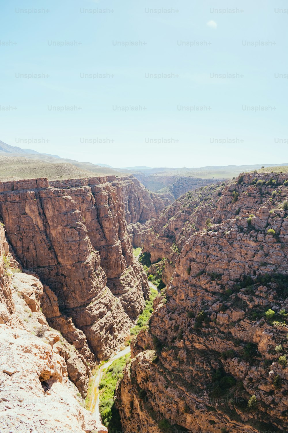 a man standing on top of a cliff next to a valley