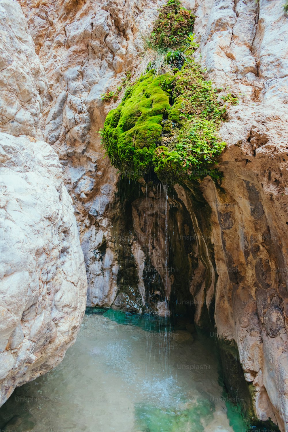 a small waterfall is coming out of a cave