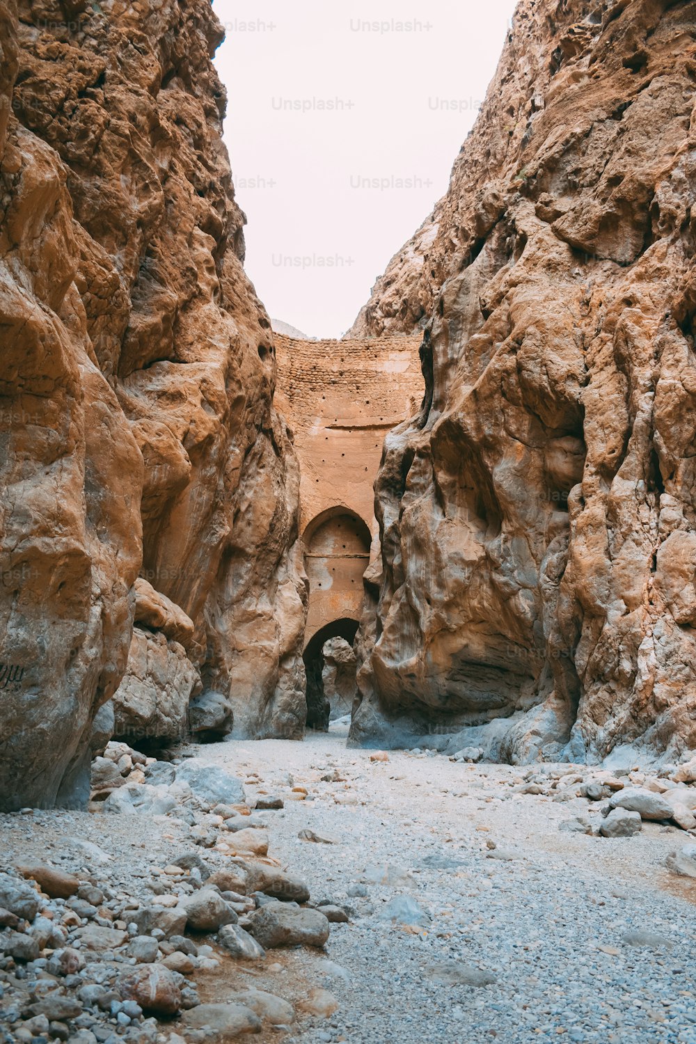 a narrow canyon with a tunnel in the middle of it