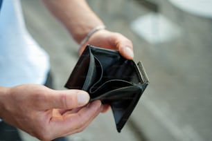 une personne tenant un portefeuille à la main
