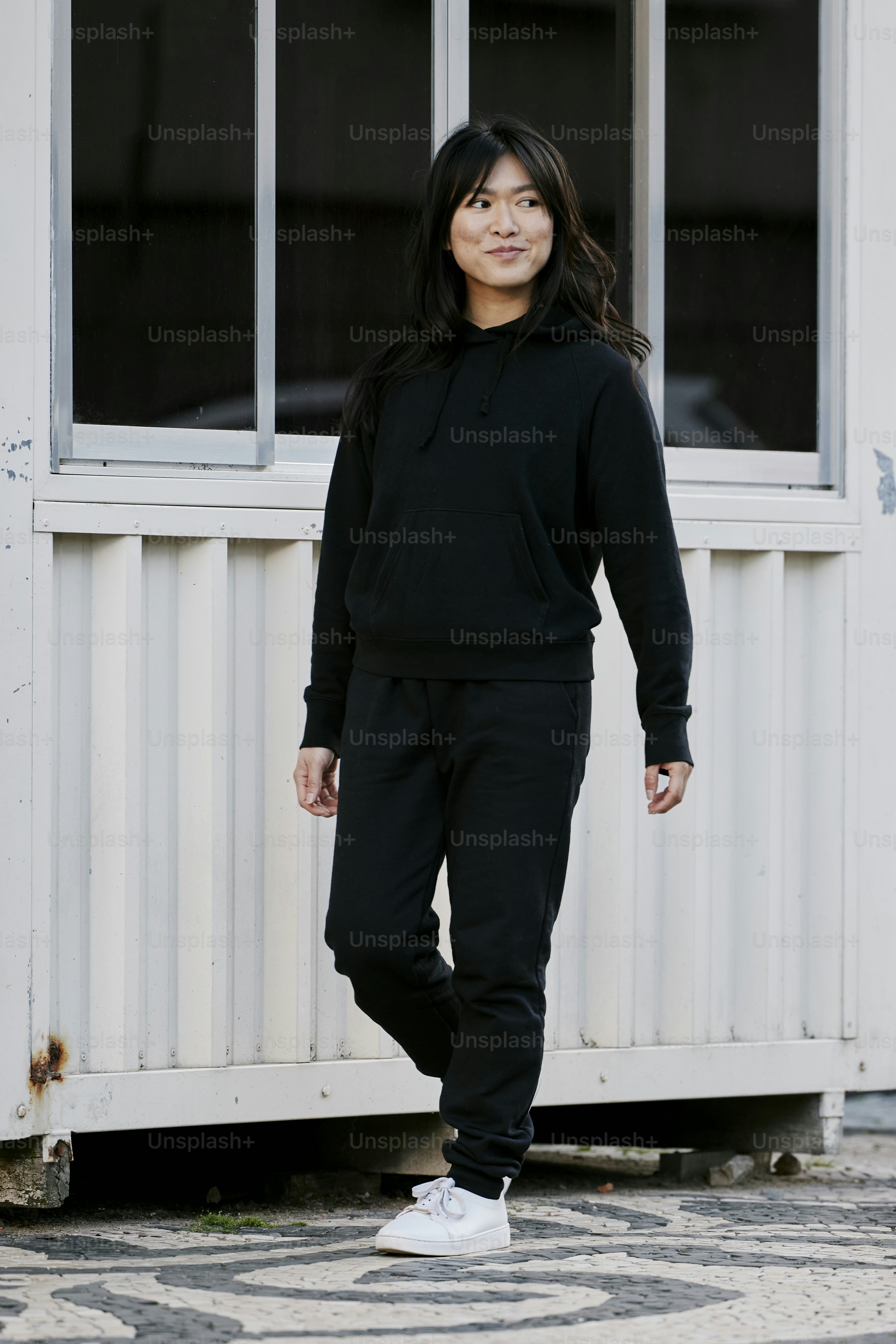 a woman standing in front of a white building