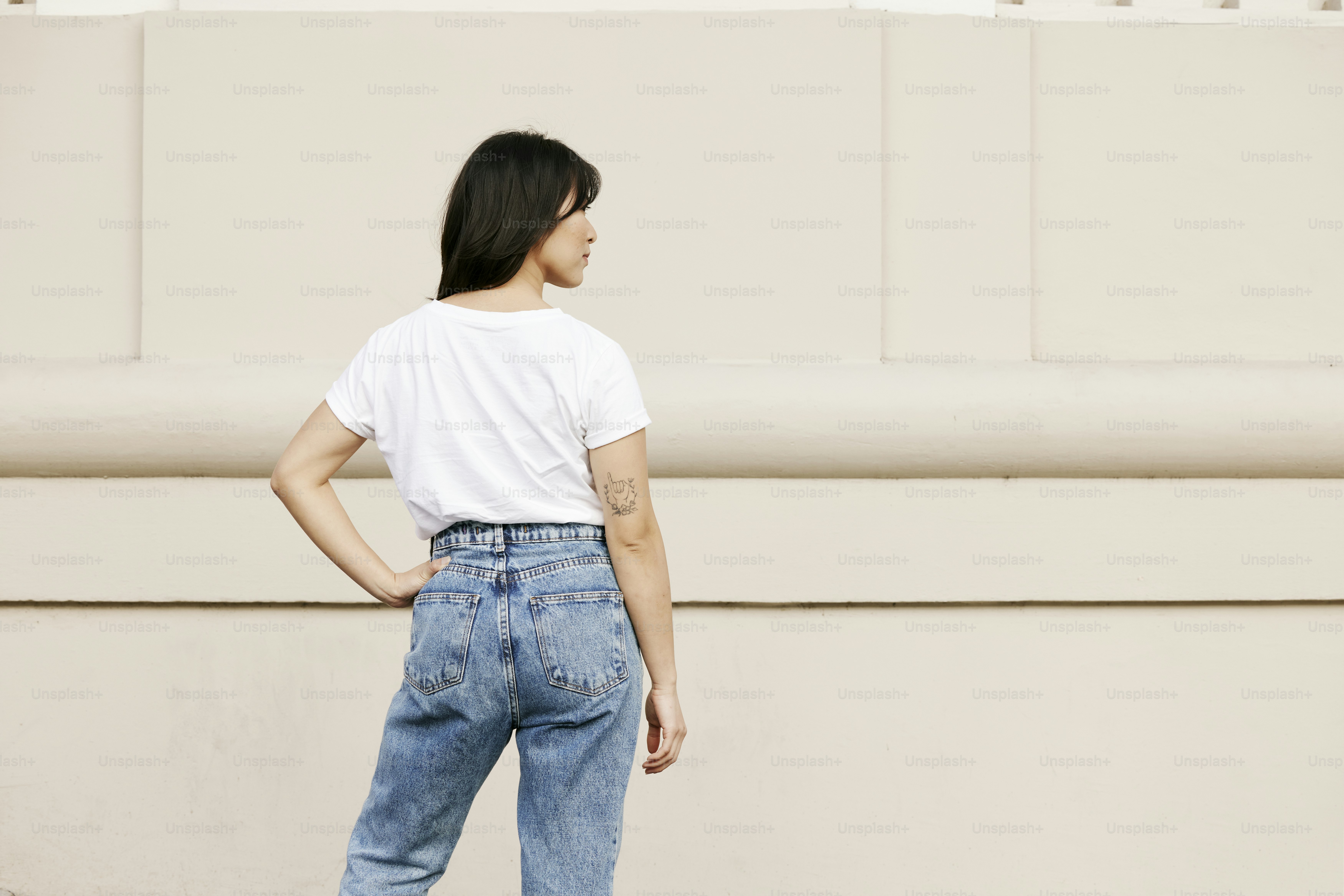 A woman standing in front of a white wall photo – T shirt Image on Unsplash
