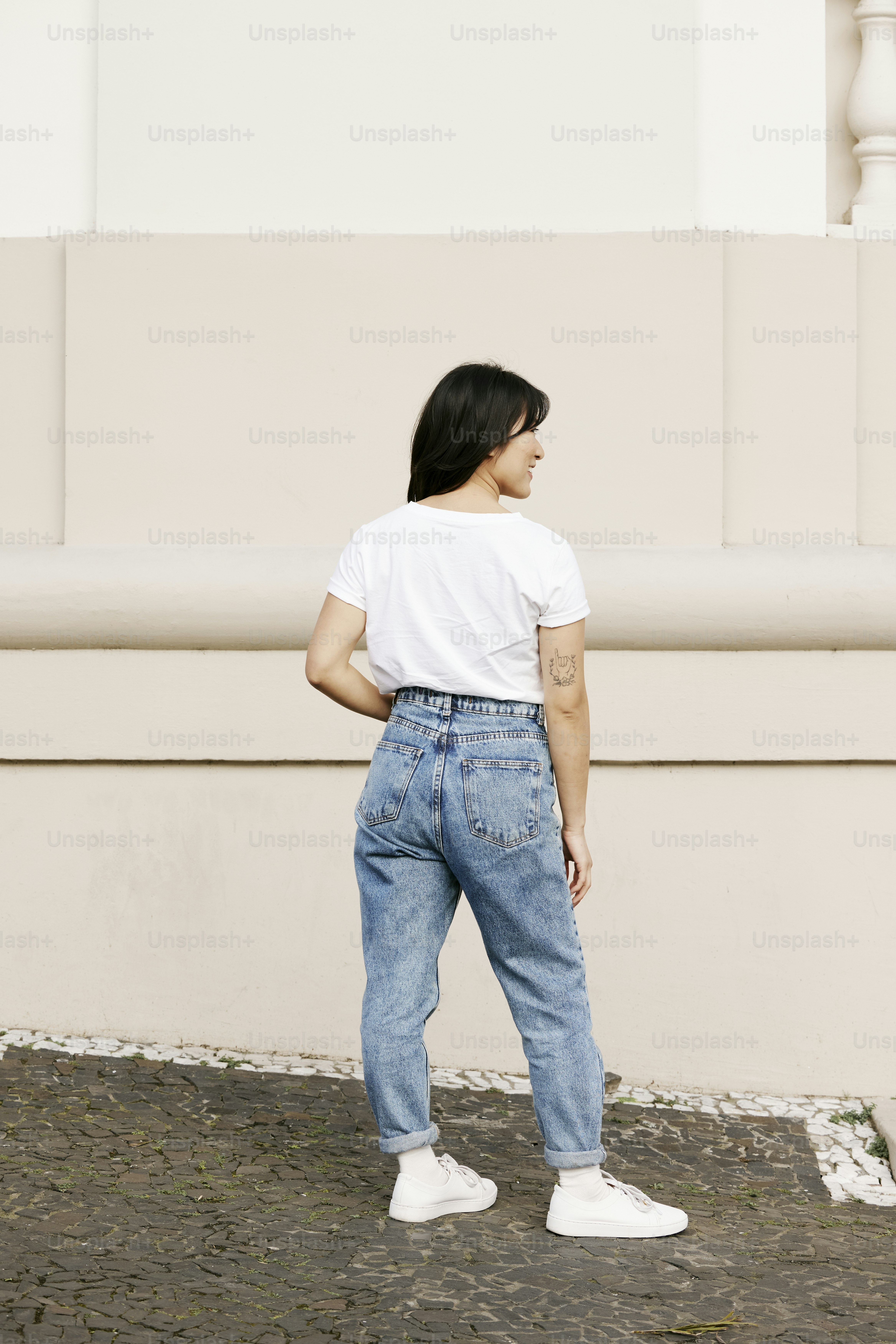 A woman in a white t - shirt and blue jeans photo – Fashion Image on ...