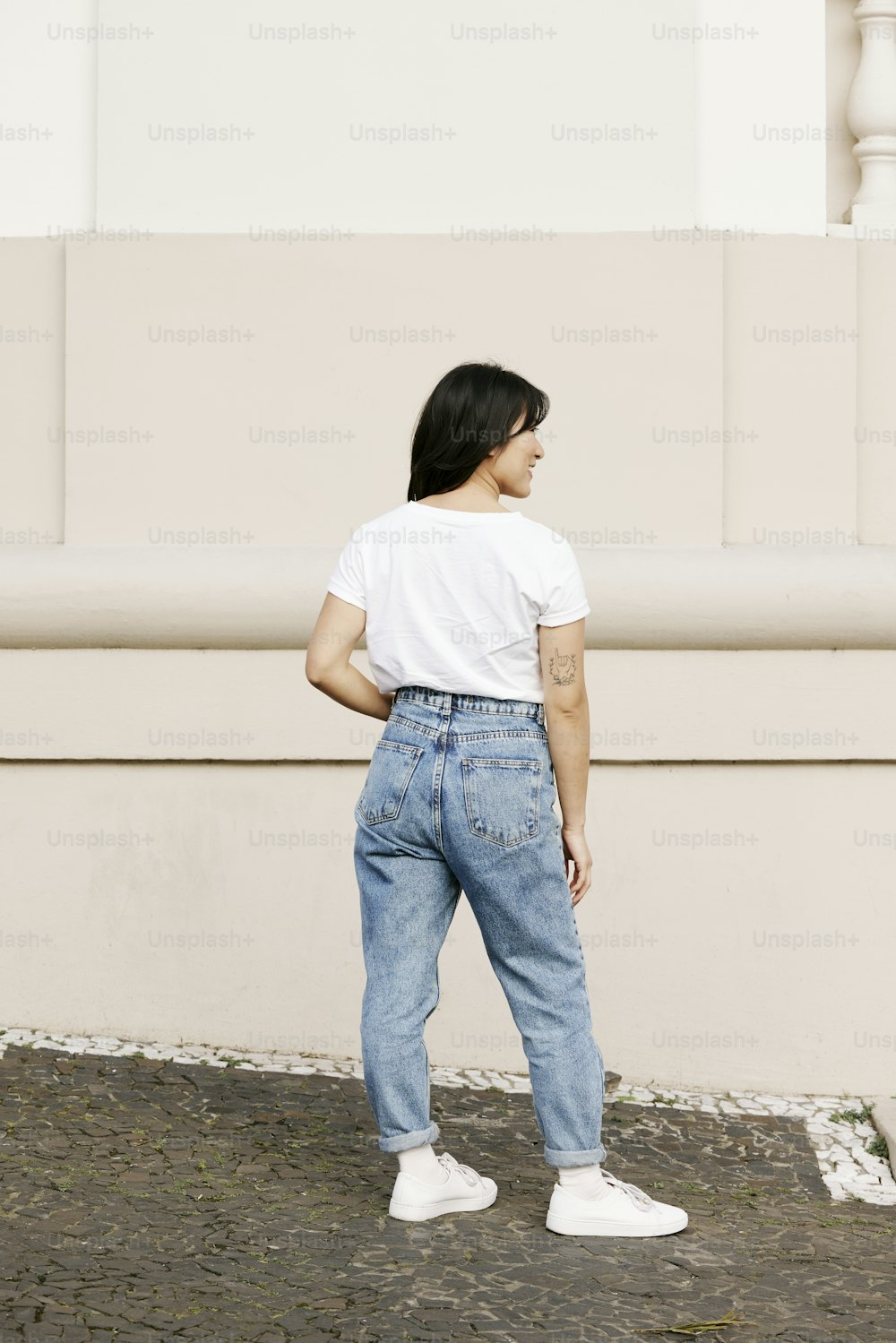 a woman in a white t - shirt and blue jeans