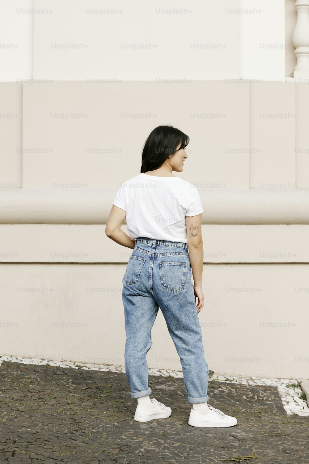 Eine Frau in einem weißen T-Shirt und blauen Jeans