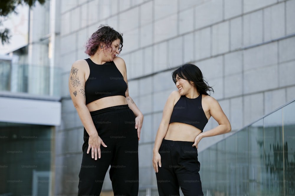 Premium Photo  Two women in black tops and leggings stand on a