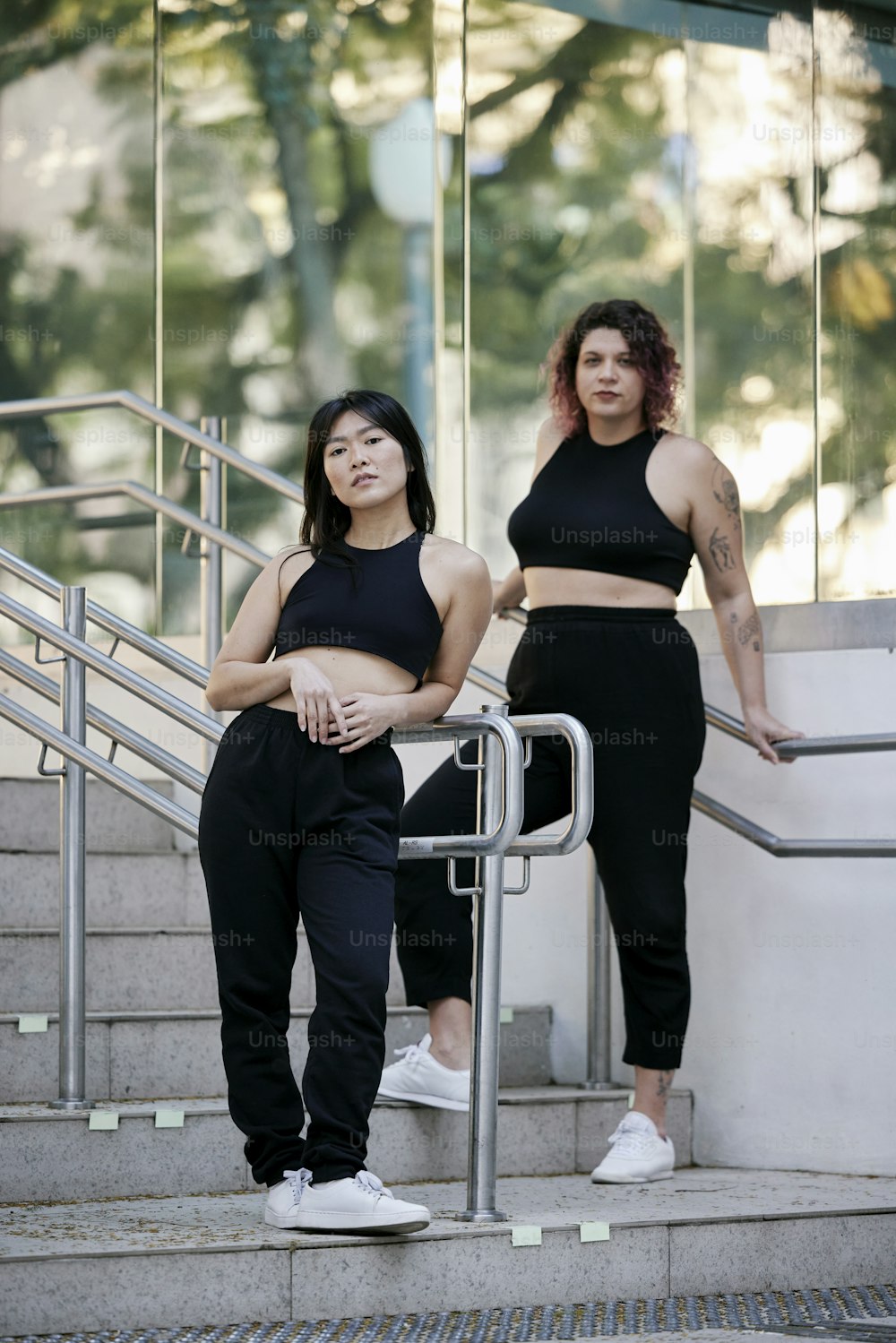 two women in black outfits standing on a set of stairs