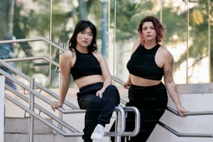 a couple of women sitting on top of a set of stairs
