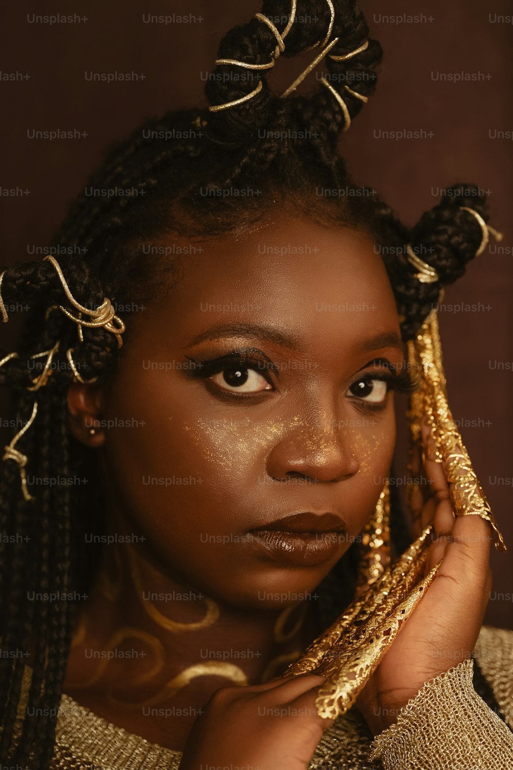 a woman with braids and gold makeup