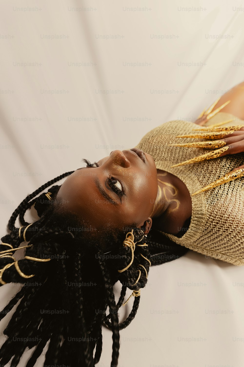 a woman with dreadlocks and a gold dress