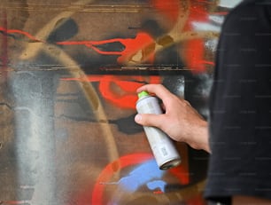 낙서로 벽을 스프레이로 칠하는 사람