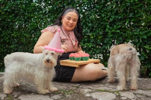una donna seduta a terra con tre cani
