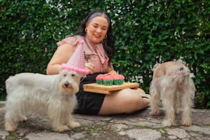 a woman sitting on the ground with three dogs