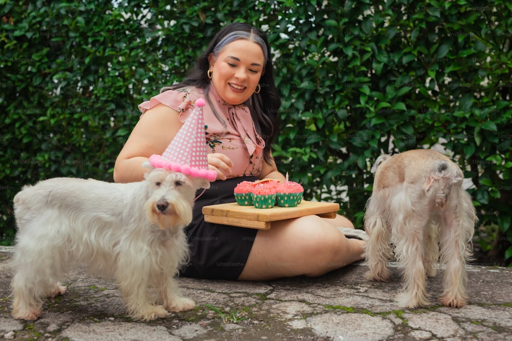 a woman sitting on the ground with three dogs
