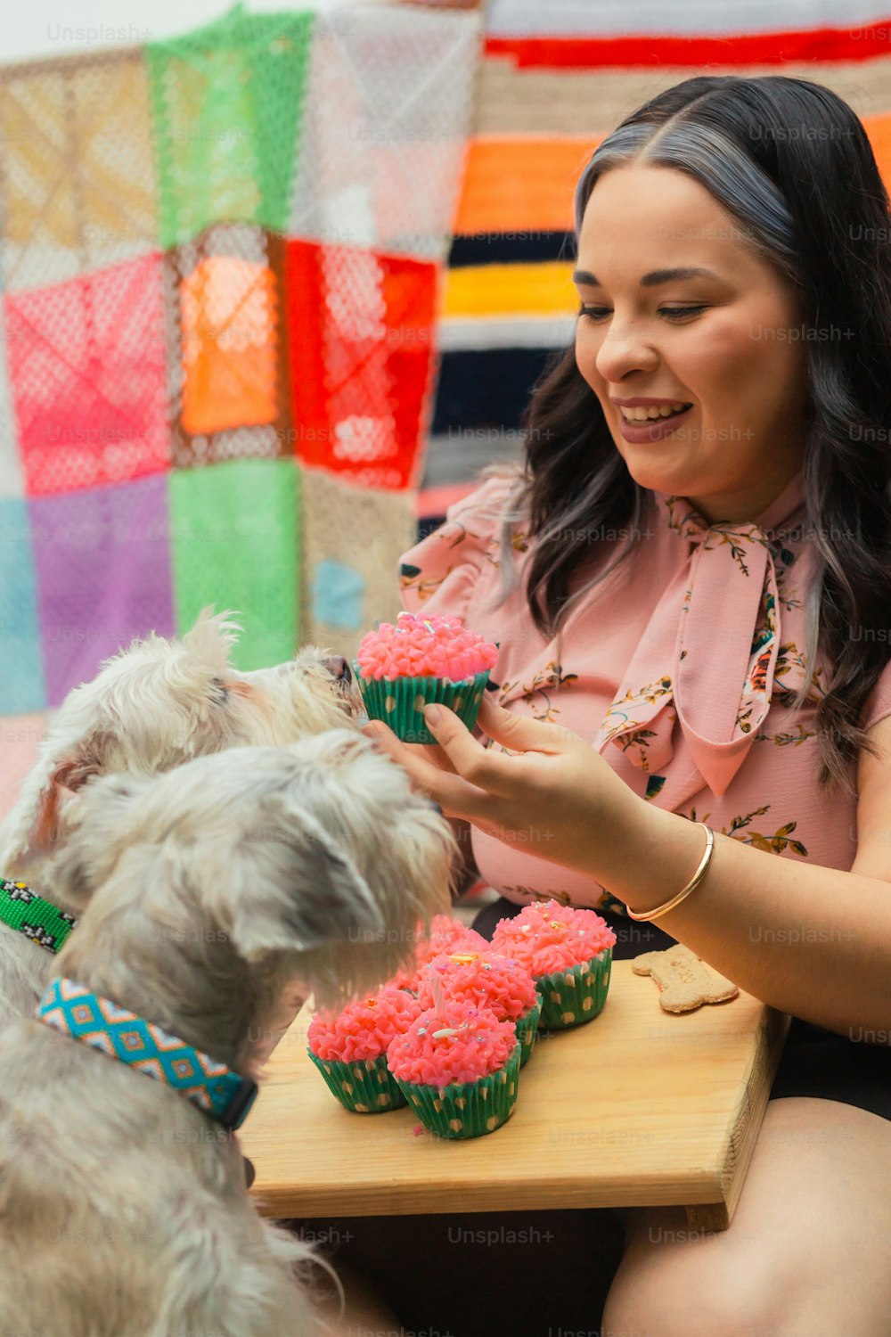 a woman is feeding cupcakes to a dog
